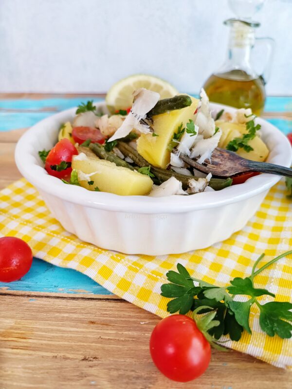 Serviamo l'insalata di merluzzo con patate, fagiolini e pomodorini a temperatura ambiente o leggermente fresca.