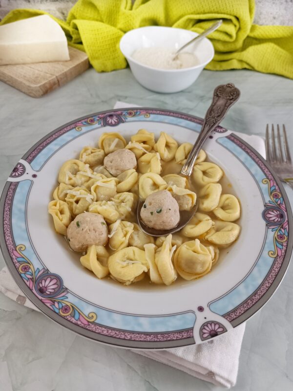 Serviamo i tortellini in brodo ben caldi, con le polpettine e una spolverata di Parmigiano Reggiano.